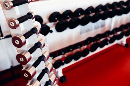 Sports equipment dumbbell rests in a row in gymの写真素材