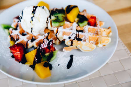 Viennese wafers with fruits: kiwi, avocado, strawberry, chocolate, ice cream, mint. Fruits cut into slices.の写真素材