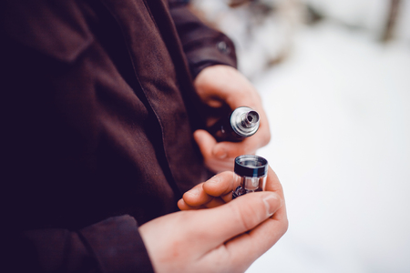 vaping man holding a mod device. cloud of vapor.の写真素材
