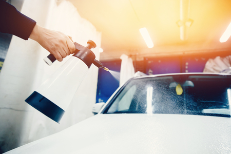 Car wash worker close-up removes stains on the car. Concept of washing a modern car with high-pressure water.Toning and highlighting.の写真素材