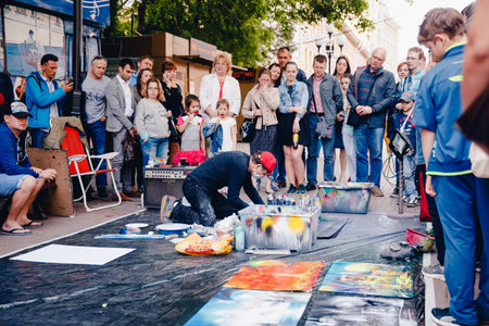 Moscow, Russia- June 12, 2017: Arbat Street. Arbat historical centre of Moscow Street art and architecture Street artist peeks for graffiti on canvas.のeditorial素材