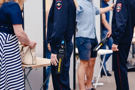 Moscow, Russia- June 12, 2017: police check the metal detector against the background of the scanning frames of people for terrorism.のeditorial素材
