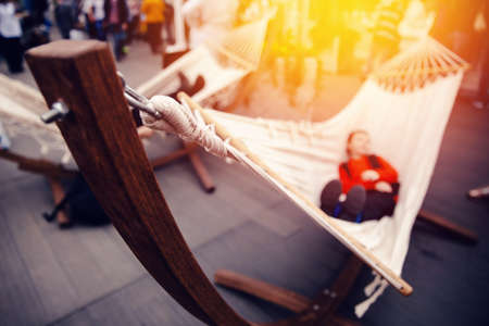 The tourist is resting in a hammock at the fair in the sunset. Concept harmony with yourself, urban vanityの写真素材