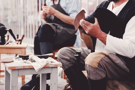 tailor master produces leather shoes. Concept of the old customs of making shoes and shoes.の写真素材