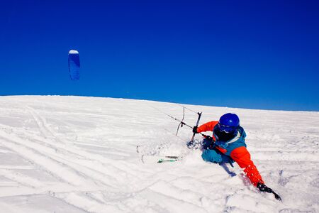 Skier with a kite on fresh snow in the winter in the tundra of Russia against a clear blue sky. Teriberka, Kola Peninsula, Russia. Concept of winter sports snowkite on ski.の写真素材