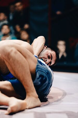 TOMSK, RUSSIA - February 12, 2017: GRAND PRIX  Power Club on MMA. Boxers fighters come out and fight in fights without rules in the ring octagon. Dark background. High contrast and monochrome color tone.のeditorial素材