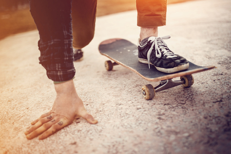 The skateboarder guy is getting ready for the start before the trick on the skateboard. Concept forward to the goal.の写真素材
