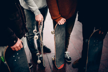Friends of the men's company hold their hands skateboards. Concept group of street athletes students