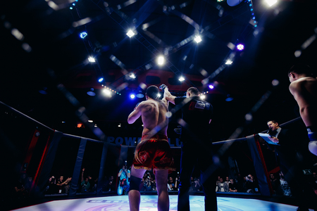 TOMSK, RUSSIA - February 12, 2017: GRAND PRIX  Power Club on MMA. Boxer fighter defeats the opponent and wins the fight.n. Dark background. High contrast and monochrome color tone.のeditorial素材