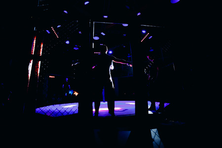 TOMSK, RUSSIA - February 12, 2017: GRAND PRIX  Power Club on MMA. Boxers fighters come out in fights without rules in the ring octagon. Dark background. High contrast and monochrome color tone.のeditorial素材