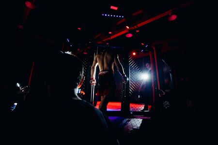 TOMSK, RUSSIA - February 12, 2017: GRAND PRIX  Power Club on MMA. Boxers fighters come out in fights without rules in the ring octagon. Dark background. High contrast and monochrome color tone.のeditorial素材