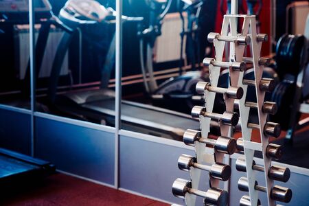 Dumbbells laid out in a row on a stand. Concept sports equipment.の写真素材