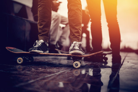 Skaters friends team outdoor in urban city with skateboards in their hands. Young people training longboard extreme sport. concept friendship. Warm filterの写真素材