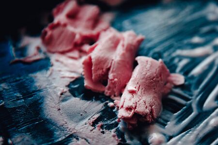 Ice cream roll fried in the fridge freezer pan on the street in Thailand, fresh cooking made from fresh strawberries, milk, blueberries. Concept of tourist delicacy.の写真素材