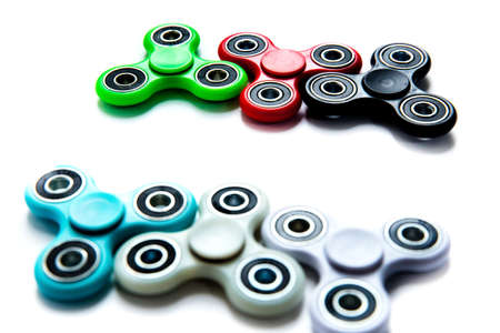 Fidget finger spinner, anxiety relief toy on white isolated background, copyspace. Concept relieving stressの写真素材
