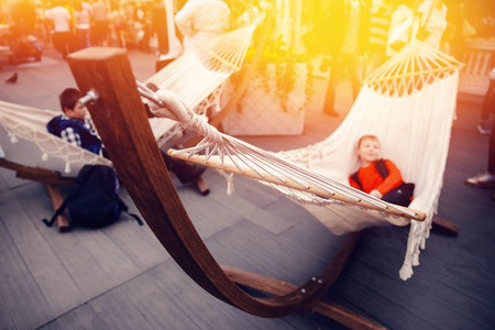 Children rest in a hammock at the city fair. Concept vacation with family, play, entertainmentの写真素材