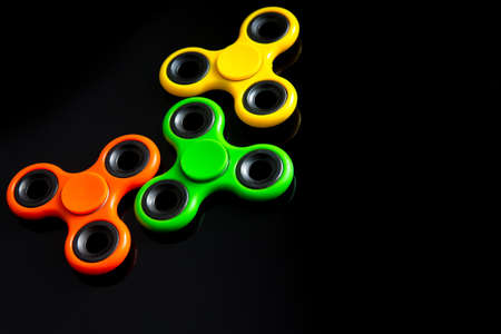 Fidget finger spinner, anxiety relief toy on black background, copyspace. Concept relieving stressの写真素材