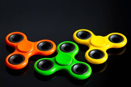 Fidget finger spinner, anxiety relief toy on black background, copyspace. Concept relieving stressの写真素材
