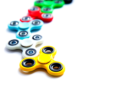 Fidget finger spinner, anxiety relief toy on white isolated background, copyspace. Concept relieving stressの写真素材