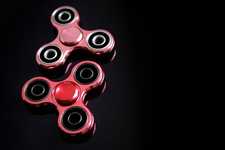 Fidget finger metal spinner, anxiety relief toy on black background, copyspace. Concept relieving stressの写真素材