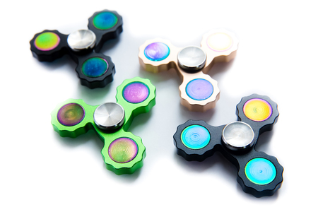 Fidget finger spinner, anxiety relief toy on white isolated background, copyspace. Concept relieving stressの写真素材