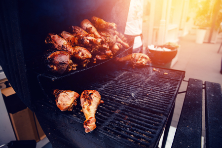 Chicken legs cooked on an open fire on the grill BBQ. Concept dinner with friends in a cafe, restaurant.の写真素材