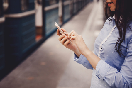 young tourist girl holds a phone, a means of communication, a fashionable gadget. The concept is always in touch.の写真素材