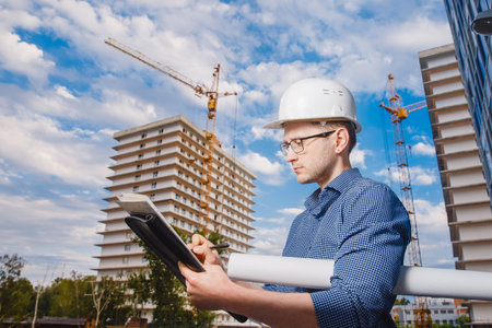 Male construction builder worker - foreman is engineer in protective helmet,glasses on the...