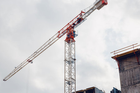 Lifting crane. Concept building of new houses from combined materials. Flare, sun.