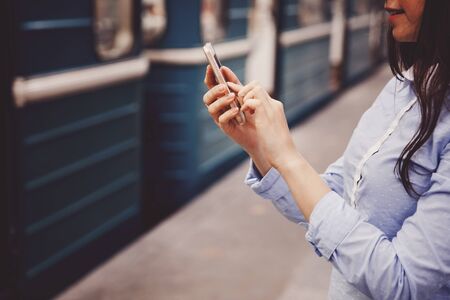 young tourist girl holds a phone, a means of communication, a fashionable gadget. The concept is always in touch.の写真素材