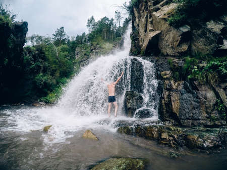 Man in Kamyshlinskiy vodopad waterfall summer, mountains Altai, Russia.の写真素材