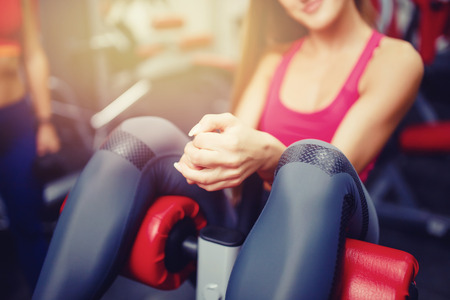 Close-up of the girl's hand, which pumps the press in the gym. The concept of doing sports, copyspaceの写真素材