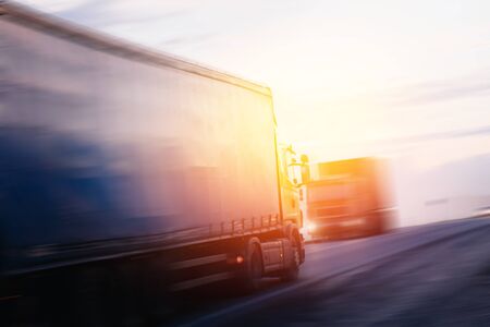 truck at sunset in motion carries cargo, a container. Concept logistics, transportation, transportation, business.の写真素材