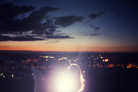 Lovers man and girl against background night city, night starry sky and horizon. Concept date Valentines Day, first kiss love.の写真素材