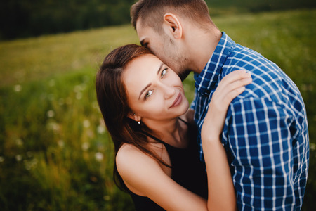 guy whispers his girlfriend in the ear compliments, words about love and tenderness. Concept lovers, a declaration of love, first love and a date.の写真素材
