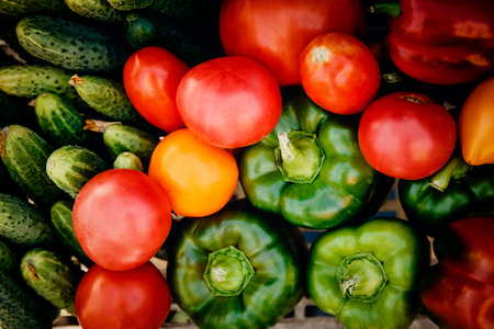 Close-up of farm products in a basket, top view: tomatoes, cucumbers, peppers. Concept is useful products, harvesting.の写真素材