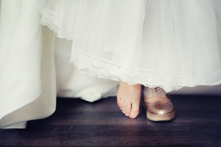 background blur bride in comfortable wedding shoes sneakers, the concept of choosing shoes shoes or sneakers or barefoot.の写真素材