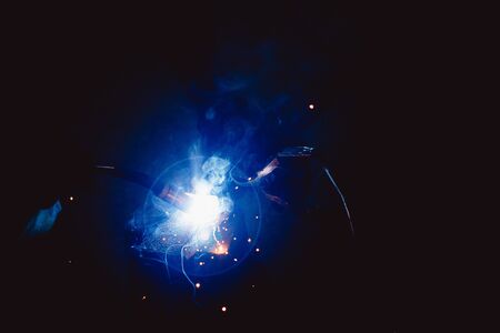 Abstract light flare from the welding machine. Flow of sparks in dark.の写真素材