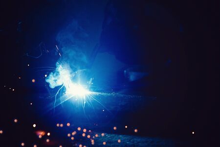 Abstract light flare from the welding machine. Flow of sparks in dark.の写真素材