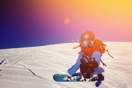 Snowboarder with a kite on fresh snow in the winter in the tundra of Russia against a clear blue sky.の写真素材