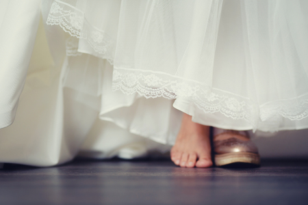 background blur bride in comfortable wedding shoes sneakers, the concept of choosing shoes shoes or sneakers or barefoot.の写真素材