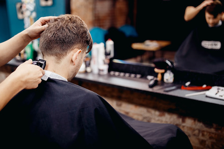 Man in barber shop mens hairdresser. Hairdresser does haircutの写真素材
