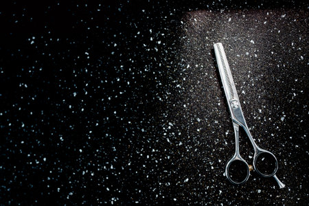Scissors for cutting hair on a dark background. Copy space