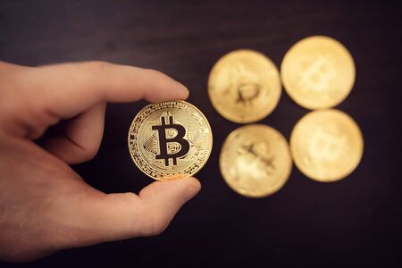 Hand holds bitcoin on a dark background. concept of crypto currency.の写真素材