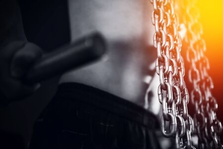 A man is an athlete with chains on uneven bars. Close-upの写真素材