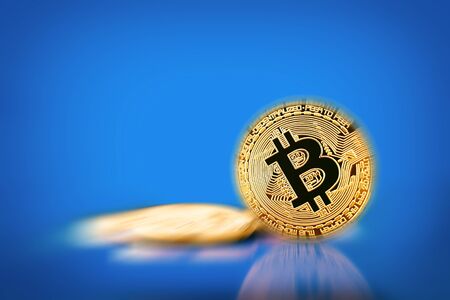 Gold Bitcoin on the blue background. Concept of crypto currency.の写真素材