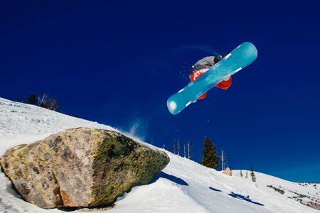 Snowboarder in flight and jumping, shows tricks.の写真素材