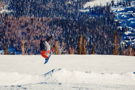 Snowboarder in flight and jumping, shows tricks.の写真素材