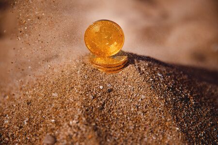 Bitcoin. Image of icon bitcoin on golden sand, in background sea. Concept freelance, stock exchange.の写真素材