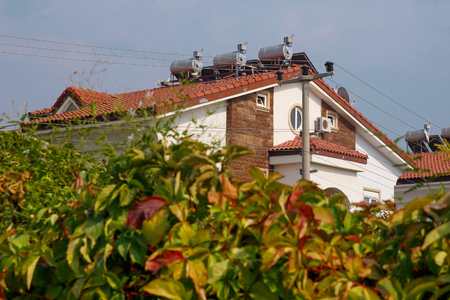 Contemporary hot water panels on a house, solar heater for green energyの写真素材
